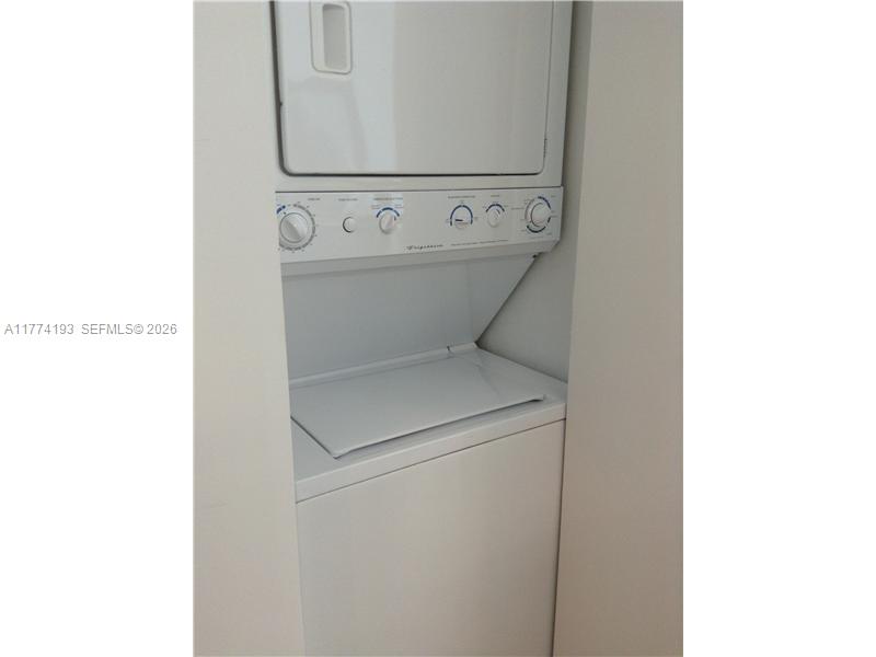 A white stacked washer and dryer unit is installed in a narrow closet — 350 NE 24th St # 1108, Miami FL 33137, MIAMI, FL