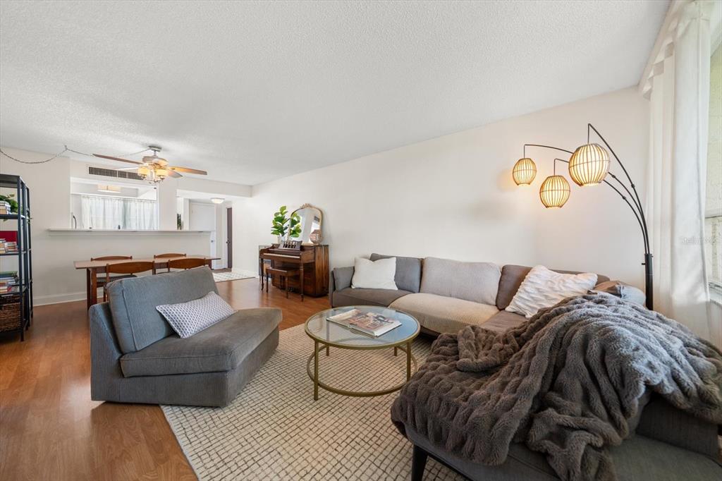 A living room features a sectional sofa, a glass coffee table, and a piano — 2614 COVE CAY DRIVE UNIT 409, CLEARWATER, FL