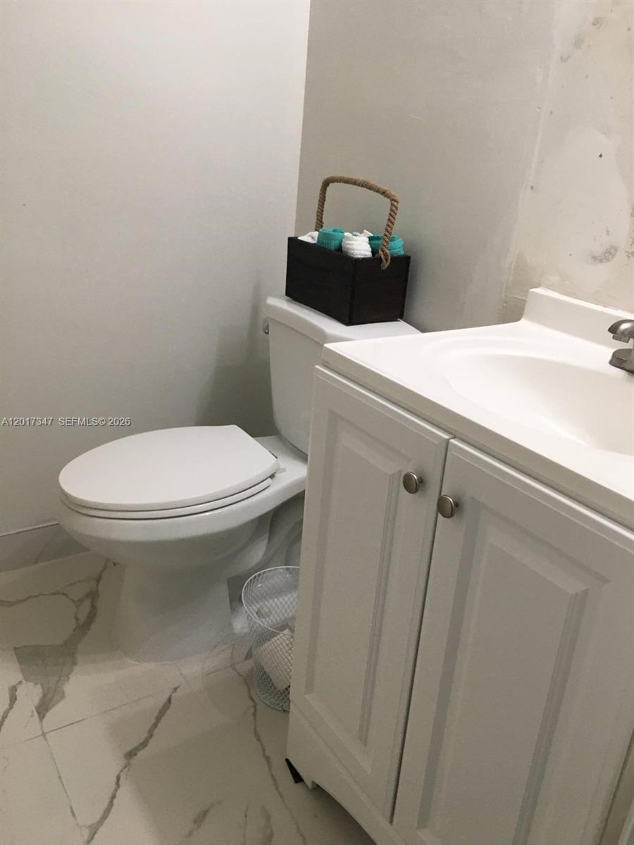 A bathroom features a white vanity, a white toilet, and light-colored marble-patterned tile flooring — 3050 E Sunrise Lakes Dr # 402, Sunrise FL 33322, SUNRISE, FL