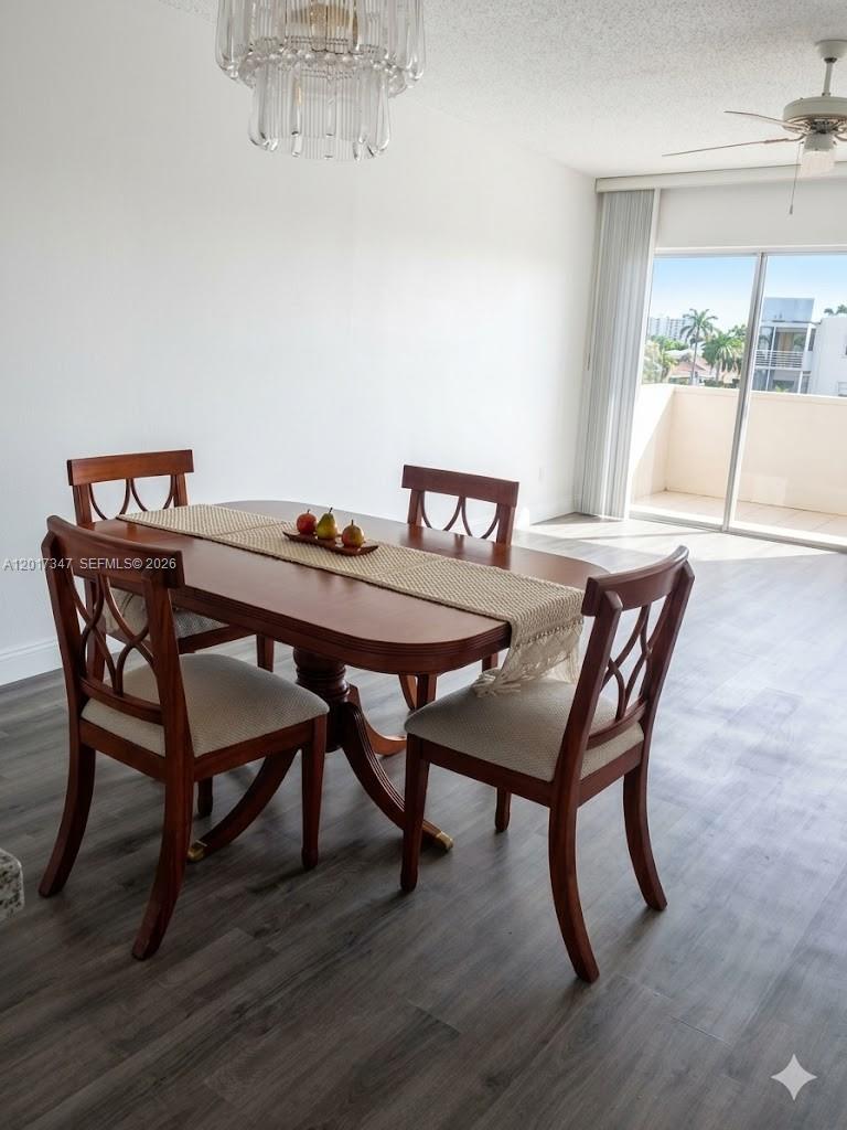 A dining area features a wooden table with four chairs, a chandelier, and a balcony — 3050 E Sunrise Lakes Dr # 402, Sunrise FL 33322, SUNRISE, FL