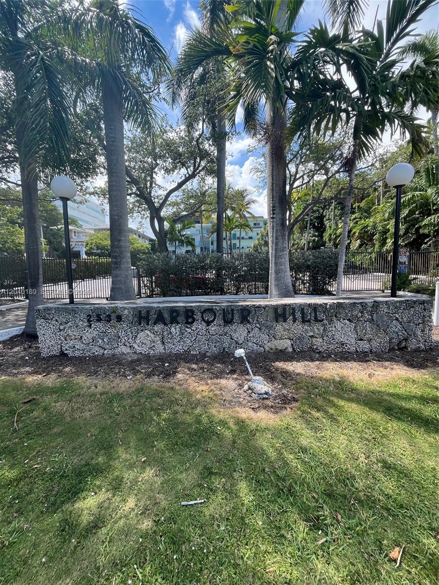 A stone sign reading Harbour Hill sits in front of palm trees and a gate — 2539 S Bayshore Dr # 320A, Miami FL 33133, MIAMI, FL