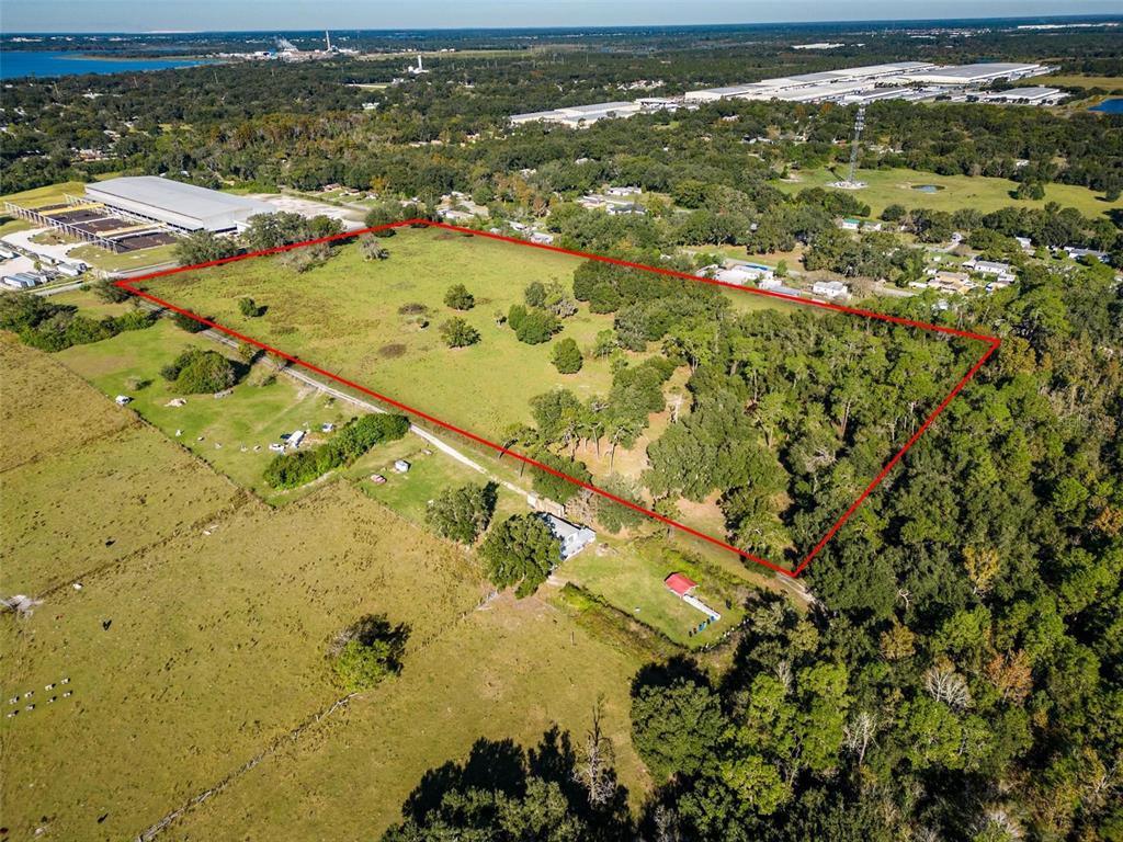 An aerial view shows a large, rectangular plot of land outlined in red with trees — 1525 FISH HATCHERY ROAD, LAKELAND, FL