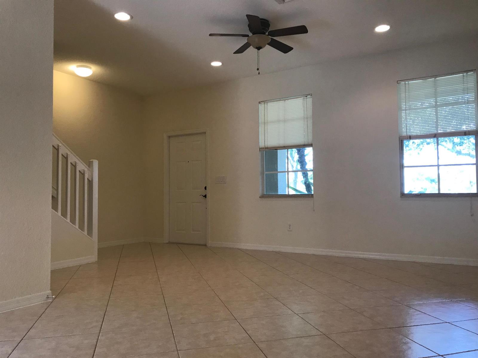 An empty room with tile flooring, a ceiling fan, recessed lighting, and a staircase — 141 E Thatch Palm Circle, Jupiter FL 33458, JUPITER, FL