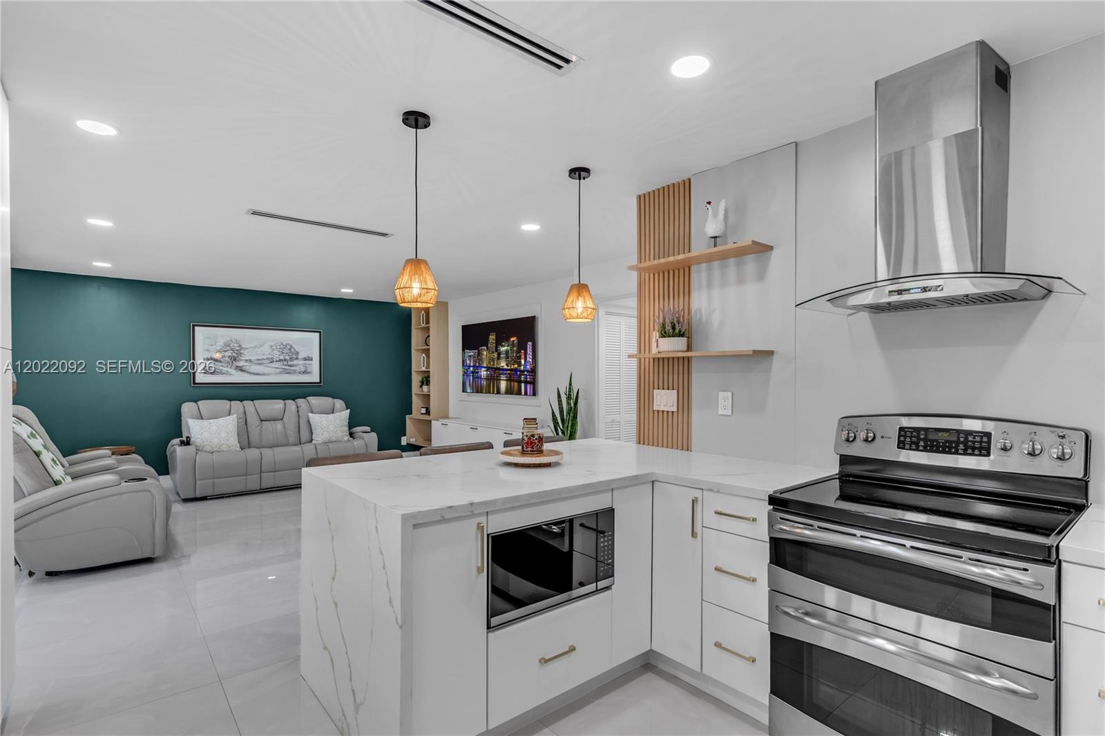A modern kitchen with white marble countertops overlooks a living area with a teal wall — 17105 SW 113th Ct # 11531E, Miami FL 33157, MIAMI, FL