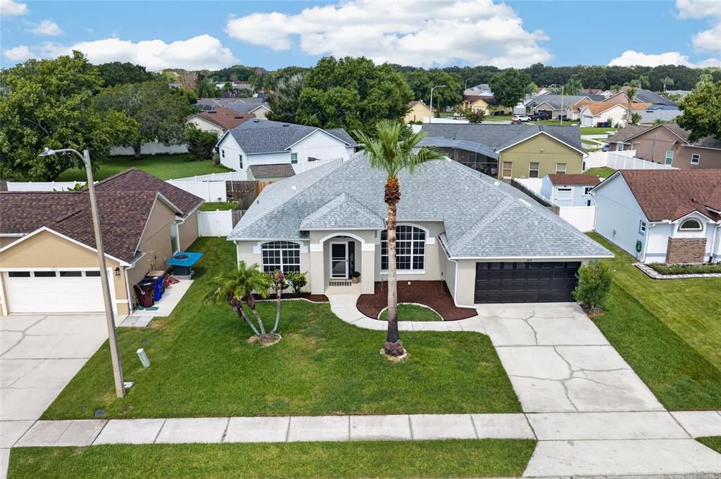 An aerial view shows a single-story suburban house with a gray roof and palm trees — 3832 BLACKBERRY CIRCLE, ST CLOUD, FL