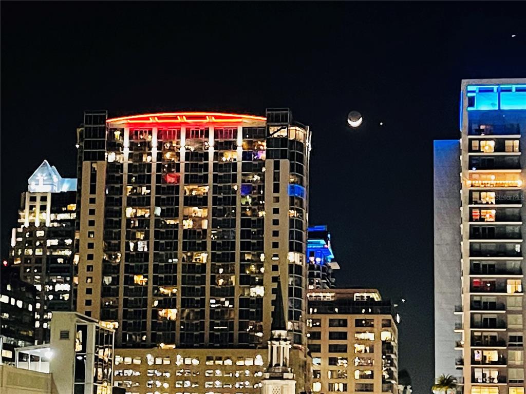 A night view of city high-rise buildings with a crescent moon in the dark sky — 155 S COURT AVENUE UNIT 1415, ORLANDO, FL