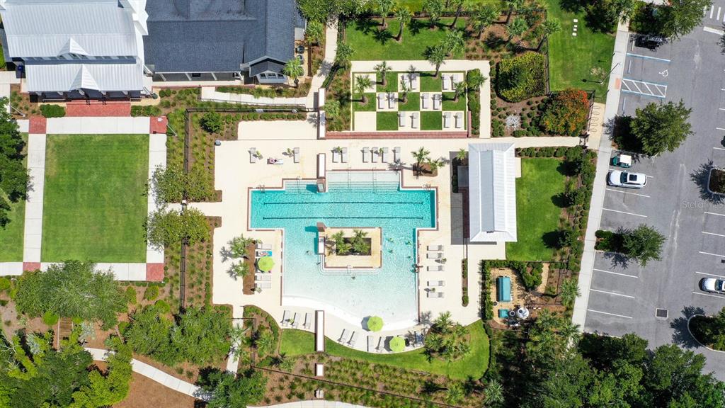 An aerial view shows a community swimming pool with a central island and surrounding lounge chairs — 1234 CANYON CREEK TRAIL, WINTER GARDEN, FL