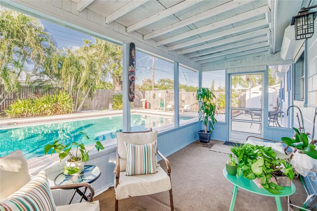 A screened-in porch with light blue walls overlooks a swimming pool and backyard — 6004 GOLF AND SEA BOULEVARD, APOLLO BEACH, FL