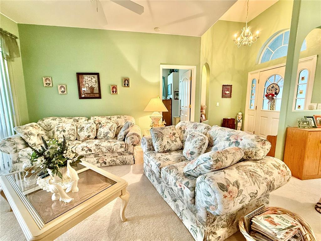 A living room features floral sofas, a glass-topped coffee table, and light green walls — 4015 CLEARFIELD STREET, NORTH PORT, FL