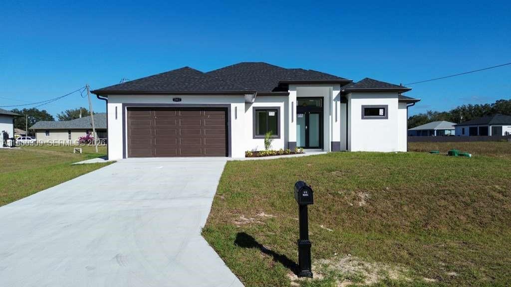 A modern, single-story white house with a dark roof and a two-car garage — 2903 E 17th St, Lehigh Acres FL 33972, LEHIGH ACRES, FL