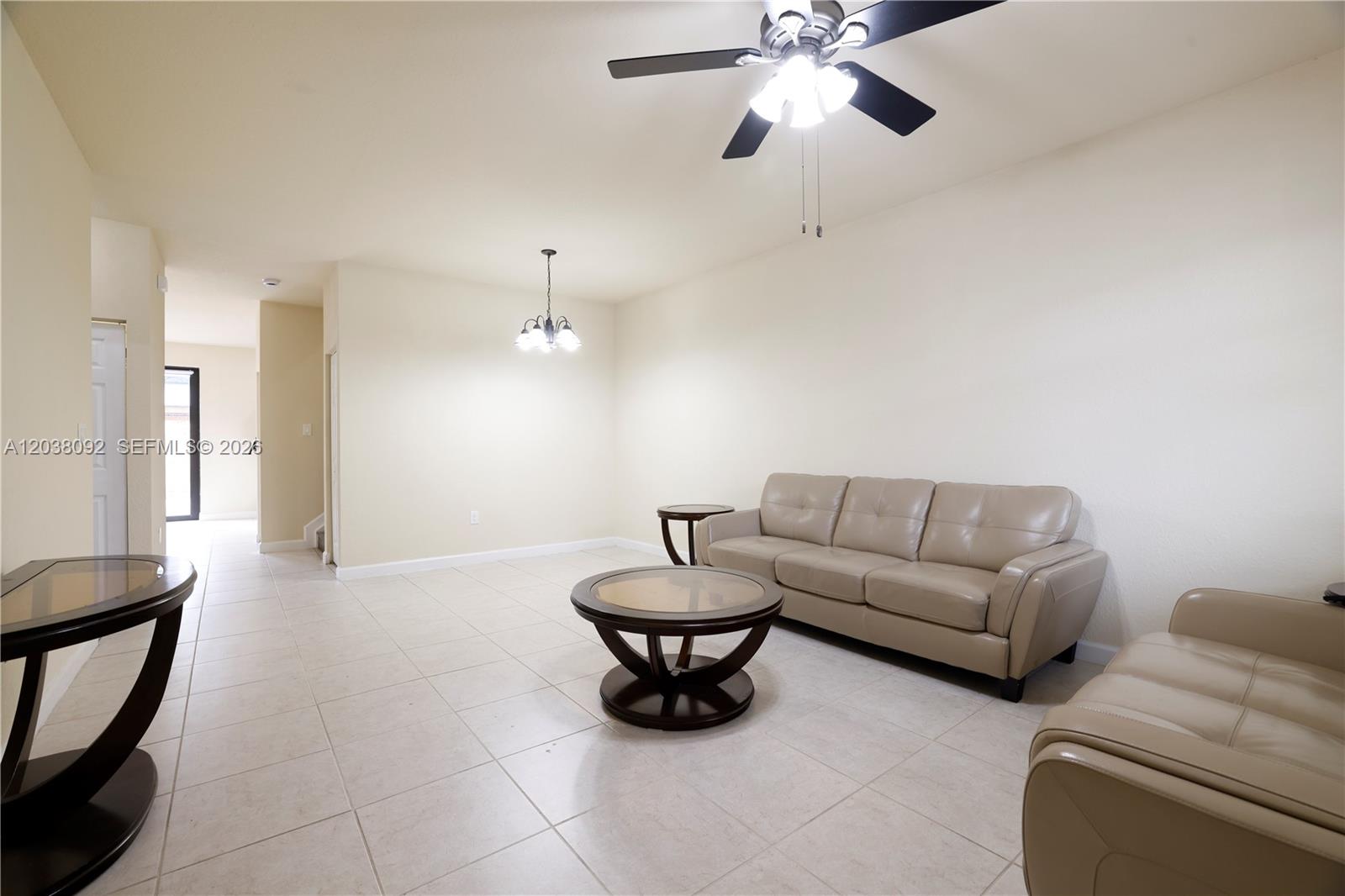 A living room features beige tile flooring, a tan leather sofa, and a ceiling fan — 7146 SW 163rd Ave, Miami FL 33193, MIAMI, FL