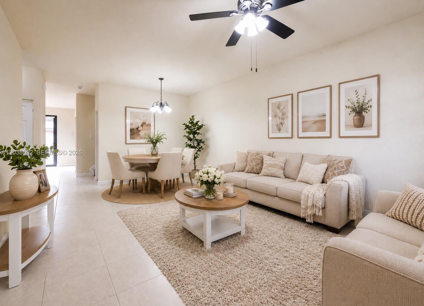 A bright living and dining area features neutral furniture, a round coffee table, and area rugs — 7146 SW 163rd Ave, Miami FL 33193, MIAMI, FL