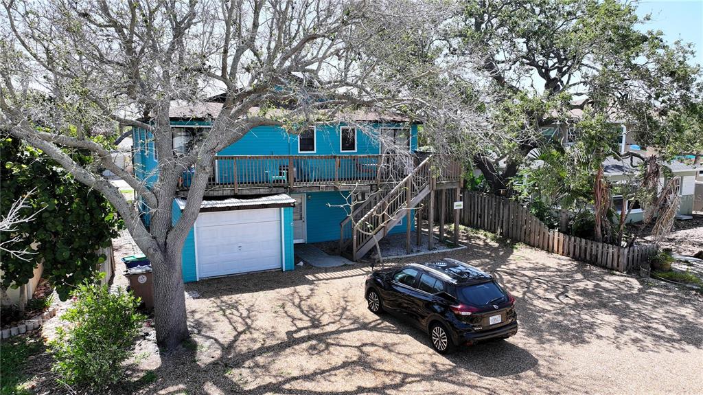 A two-story blue house with a white garage door and a wooden deck — 725 1ST STREET, INDIAN ROCKS BEACH, FL
