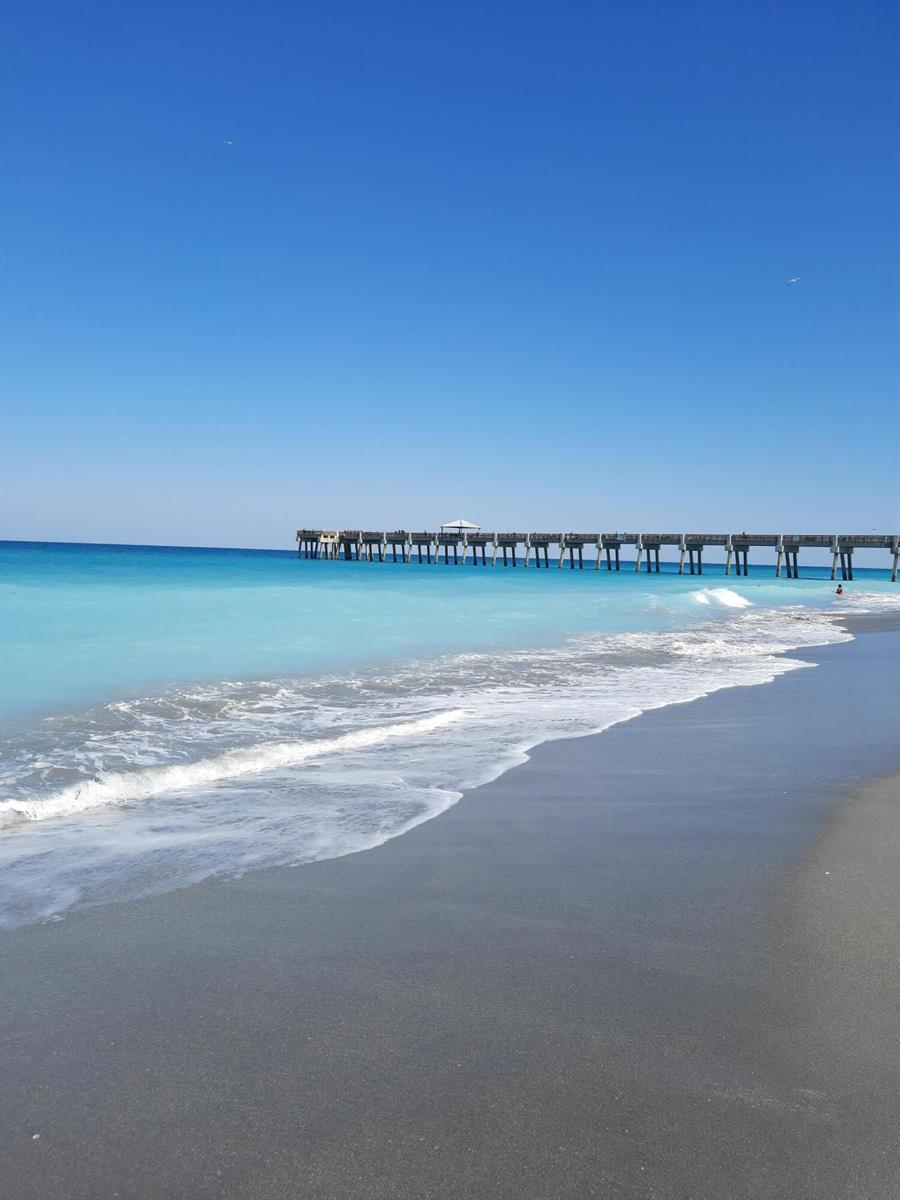 A long wooden pier extends into the turquoise ocean under a clear blue sky — 1206 Mainsail Circle, Jupiter FL 33477, JUPITER, FL