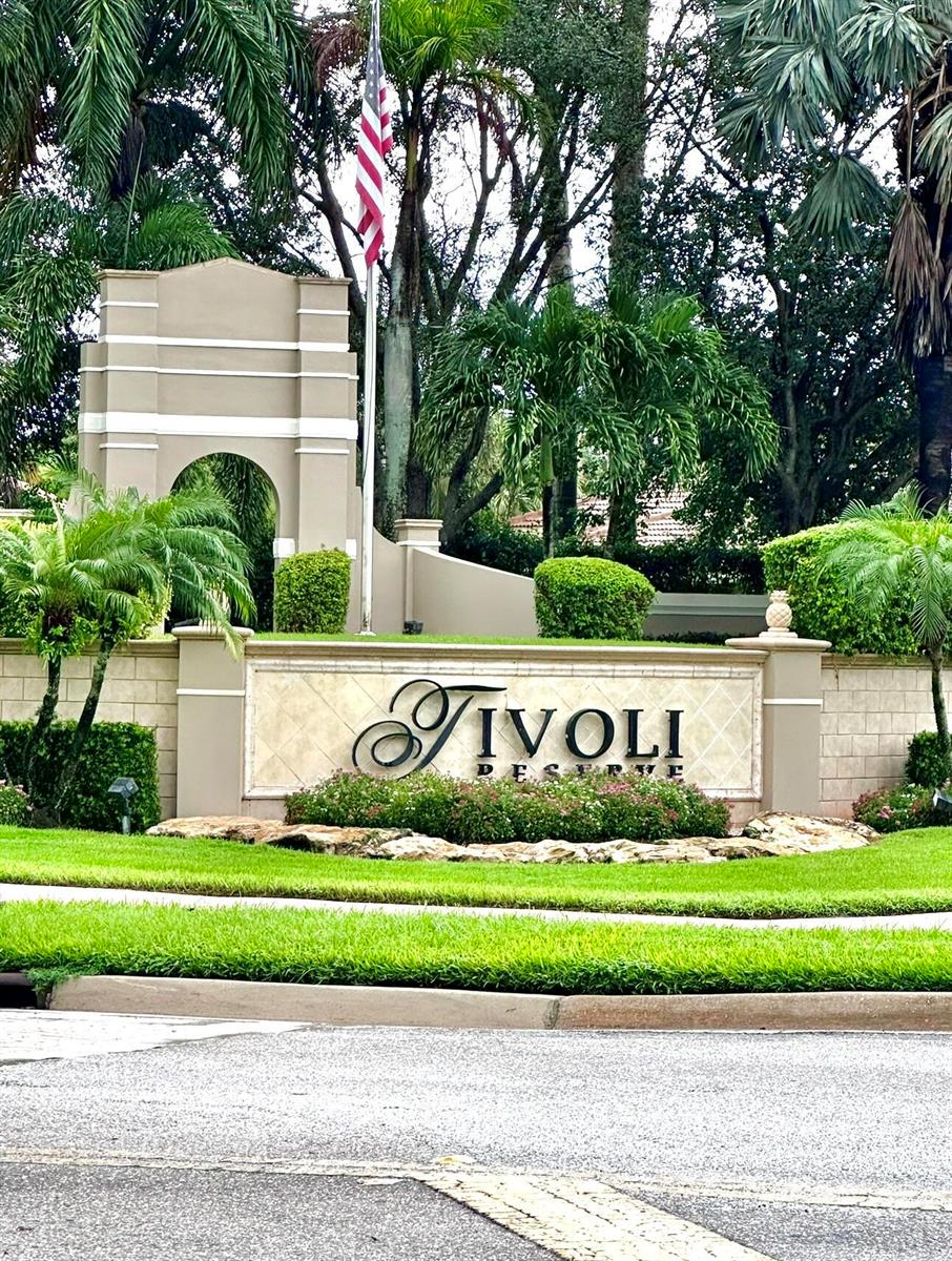 A stone entrance sign for Tivoli Reserve sits in front of landscaping and an arched wall — 8041 E Via Grande, Boynton Beach FL 33437, BOYNTON BEACH, FL
