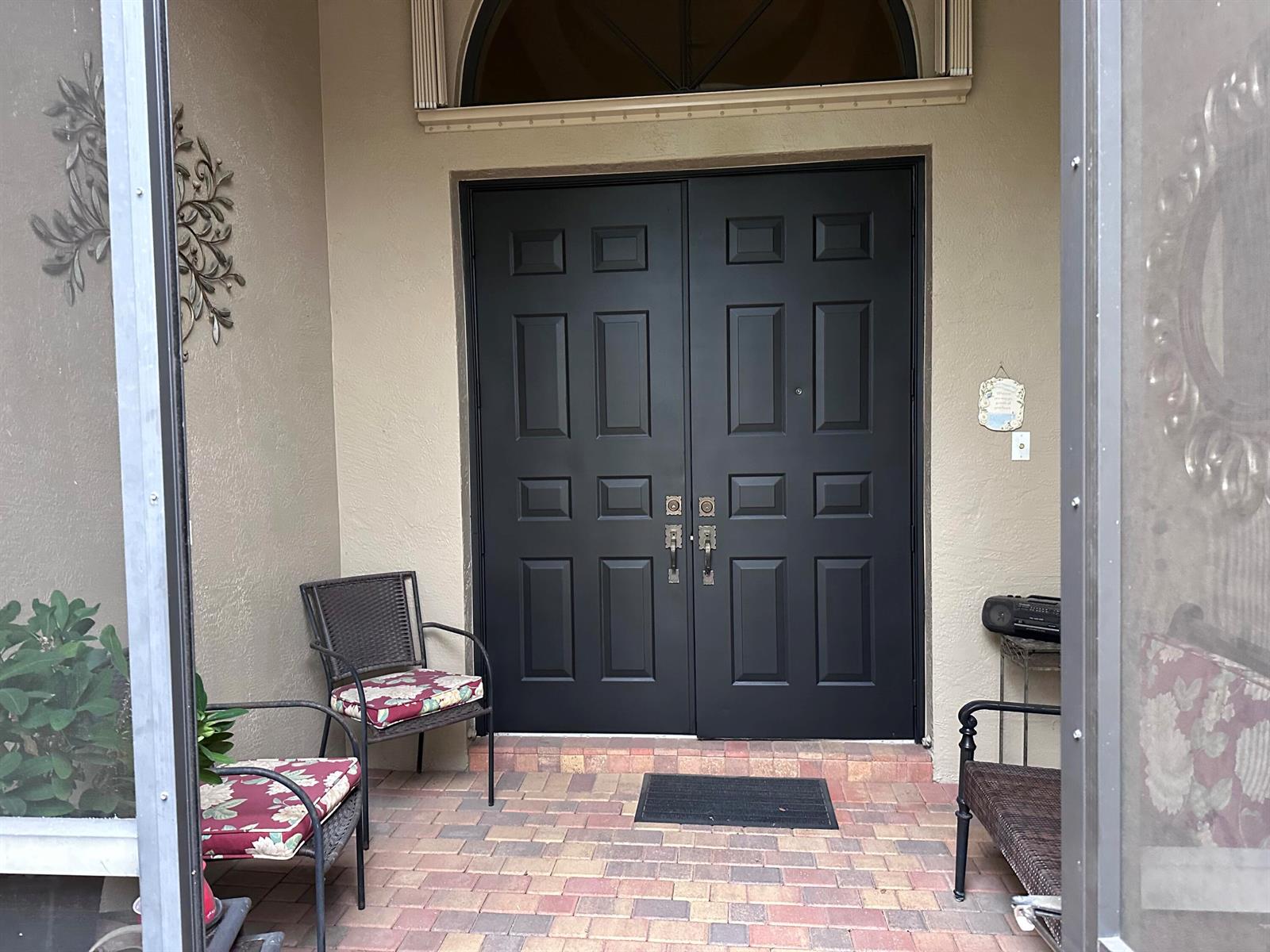 A front entryway features black double doors, a brick patio, and two chairs — 8041 E Via Grande, Boynton Beach FL 33437, BOYNTON BEACH, FL