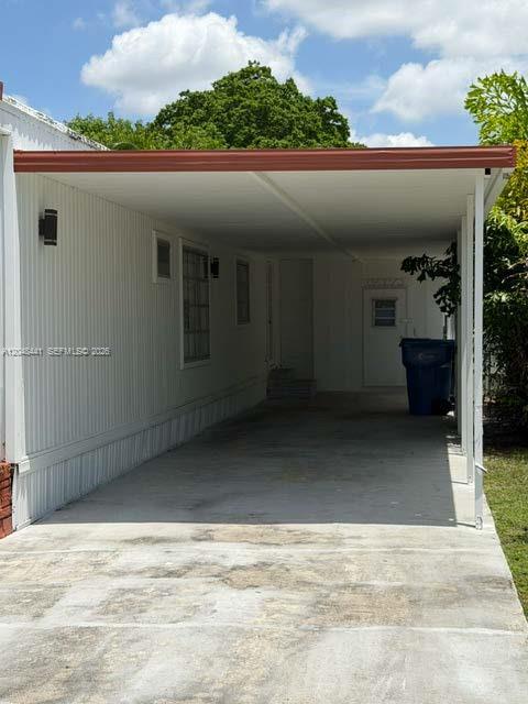 A concrete driveway leads to a covered carport attached to the side of a white house — 5331 SW 35th ST, Davie FL 33314, DAVIE, FL