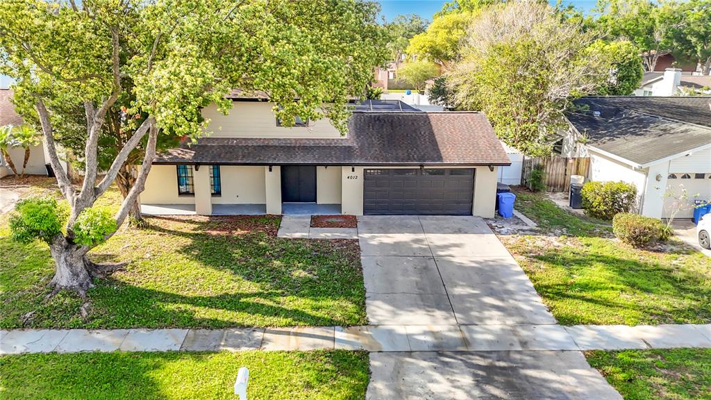 An aerial view of a two-story house with a brown roof and a concrete driveway — 4012 BRAESGATE LANE, TAMPA, FL