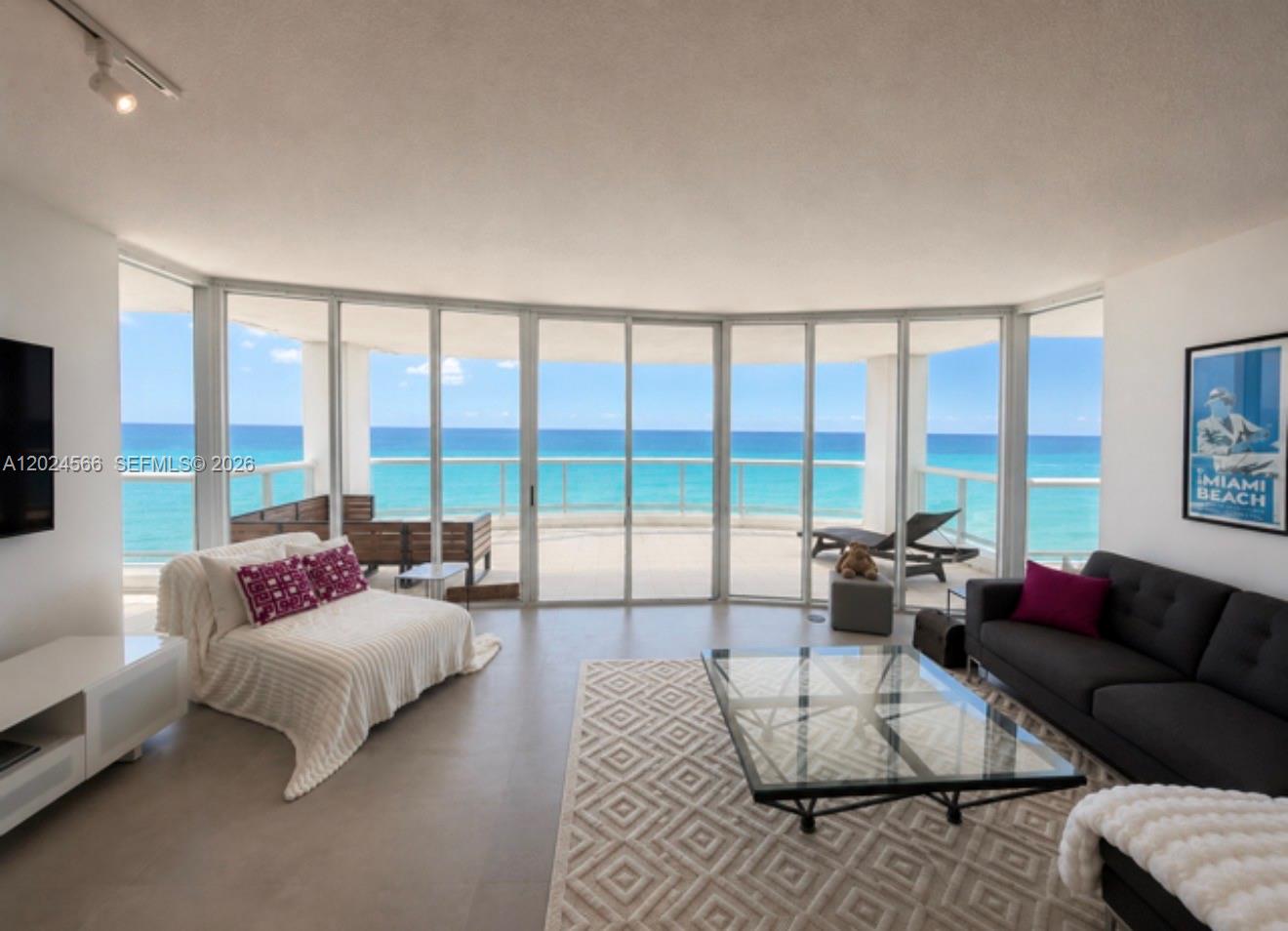 A living room features floor-to-ceiling windows with an ocean view and a balcony — 4201 Collins Ave # 1503, Miami Beach FL 33140, MIAMI BEACH, FL