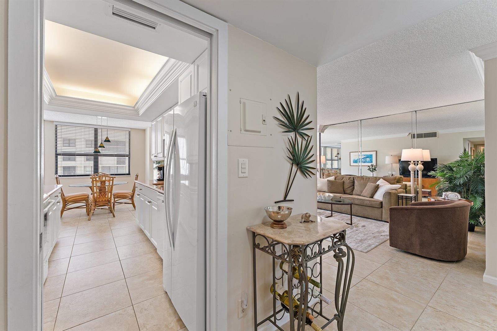 A view from a hallway looking into a kitchen and a living room with tile floors — 5480 N Ocean Drive, Singer Island FL 33404, SINGER ISLAND, FL