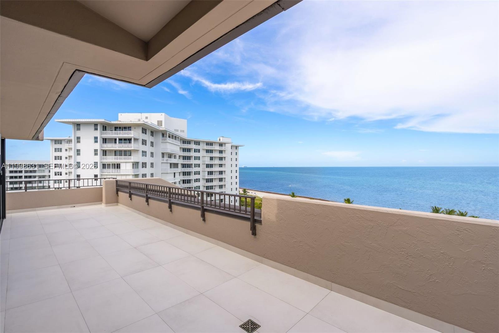 A spacious balcony features light-colored tile flooring, a metal railing, and an ocean view — 251 Crandon Blvd # 1037, Key Biscayne FL 33149, KEY BISCAYNE, FL