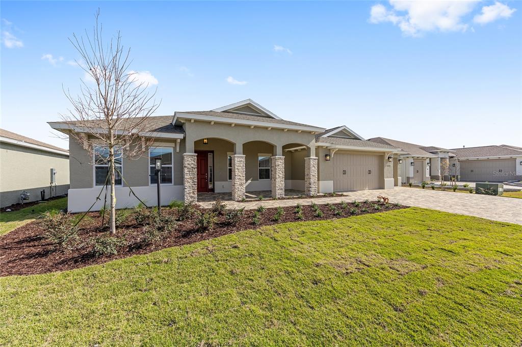A single-story house with a stone-accented porch, a two-car garage, and a landscaped front yard — 8425 SW 101ST AVENUE, OCALA, FL