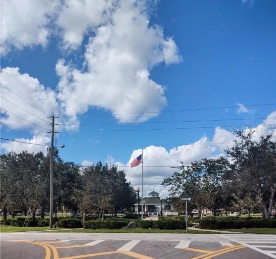 A park with a gazebo and an American flag under a blue sky with clouds — 354 CARTIER AVENUE, LAKE PLACID, FL