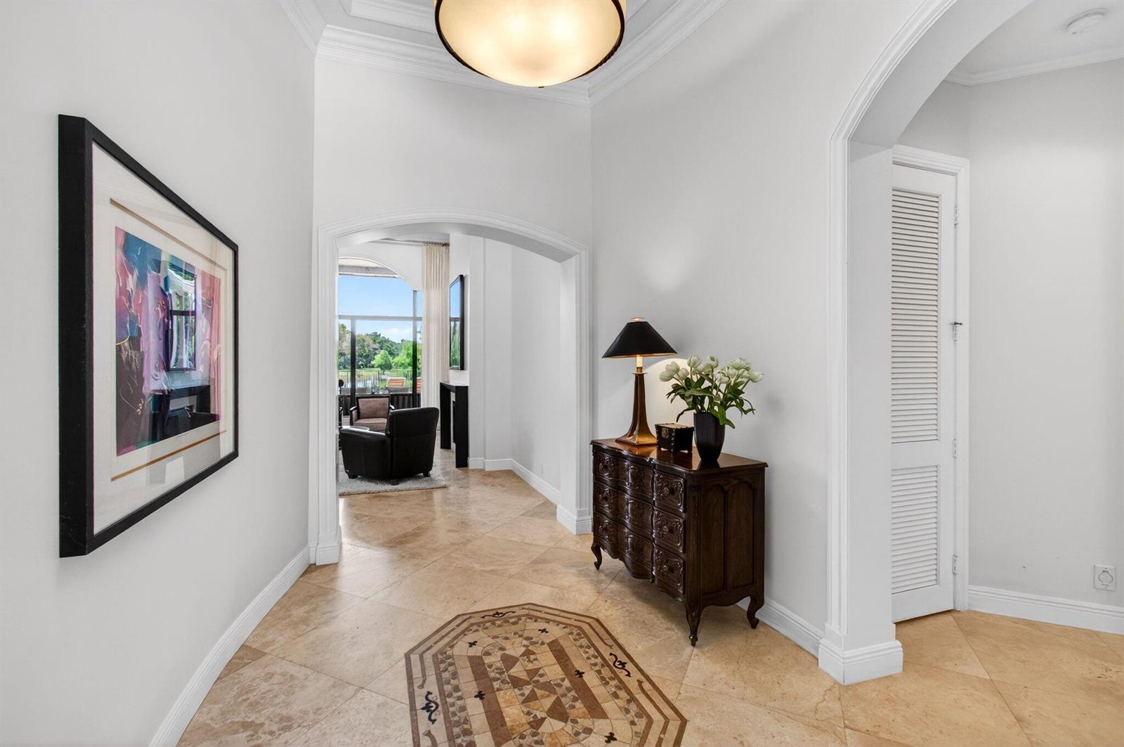 A tiled foyer features a dark wood chest, a lamp, and an arched entryway — 16266 Rosecroft Terrace, Delray Beach FL 33446, DELRAY BEACH, FL