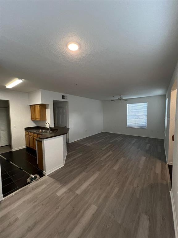 An open-concept living area features wood-look flooring and a kitchen with a breakfast bar — 5963 WESTGATE DRIVE UNIT 1414, ORLANDO, FL