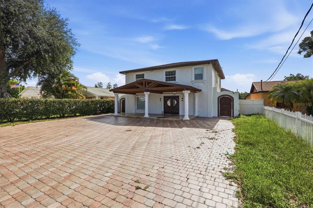 A two-story house with a paved driveway and a covered front porch with columns — 6611 N HALE AVENUE, TAMPA, FL