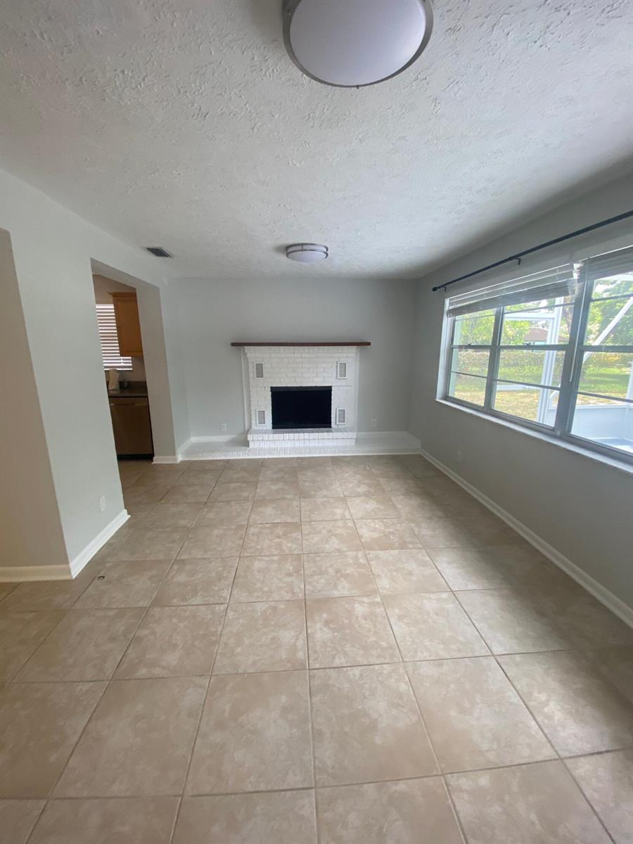 A single-story house with a light green exterior, a white garage door, and a concrete driveway — 1317 Willow Road, West Palm Beach FL 33406, WEST PALM BEACH, FL