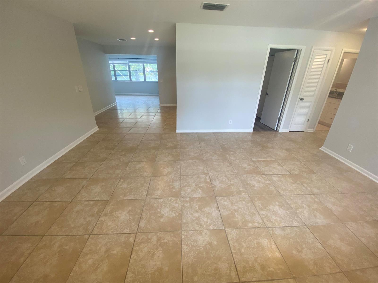 The exterior of a single-story house features a garage, a covered entryway, and light green stucco — 1317 Willow Road, West Palm Beach FL 33406, WEST PALM BEACH, FL