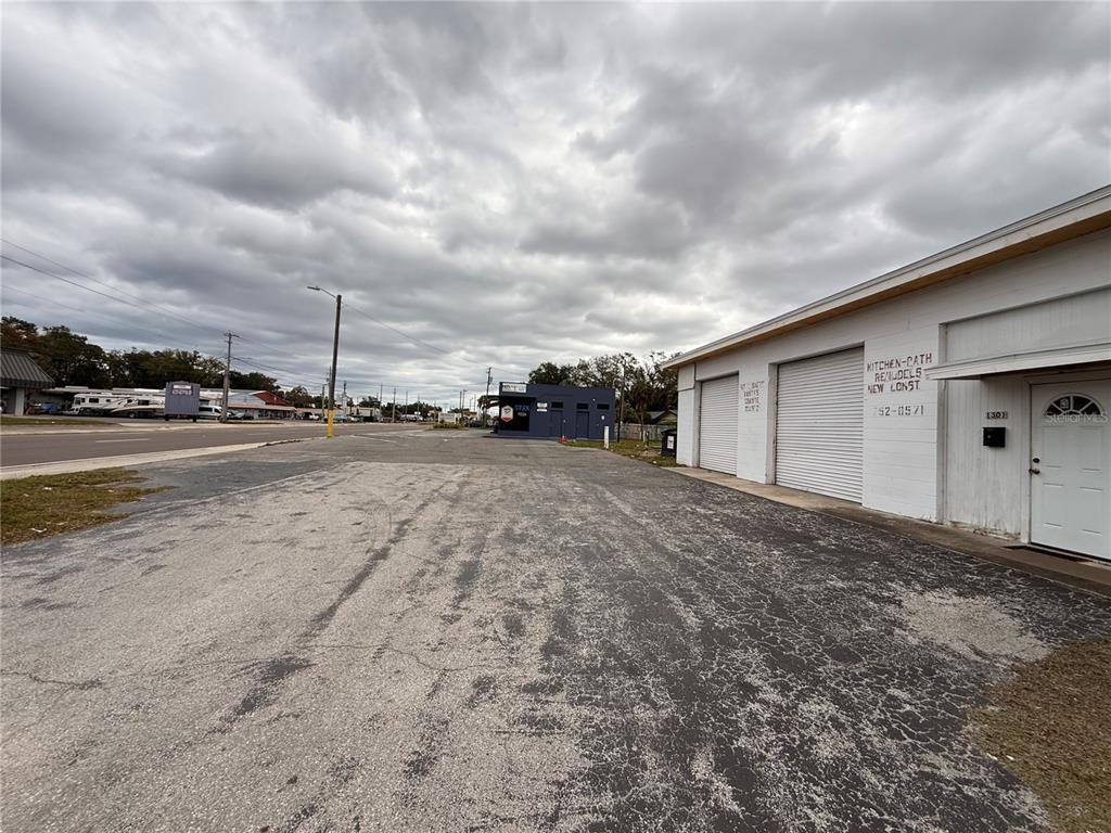 An exterior view of a commercial building with a large paved parking lot — 1305 E BAKER STREET, PLANT CITY, FL
