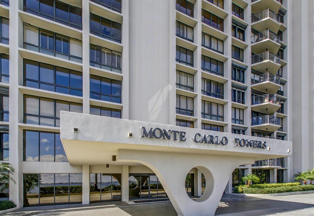The exterior of the Monte Carlo Towers building features a prominent white arched entrance canopy — 3301 BAYSHORE BOULEVARD UNIT 505C, TAMPA, FL