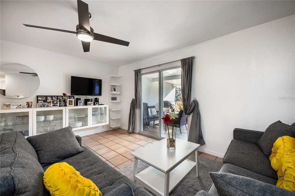 A living room features gray sofas, a white coffee table, and a sliding glass door — 1522 SE 25TH STREET UNIT D, OCALA, FL