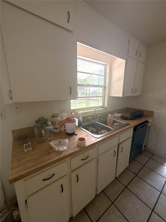 A kitchen features white cabinets, a double-basin sink, and a wood-look laminate countertop — 2188 NW 42ND AVENUE, GAINESVILLE, FL