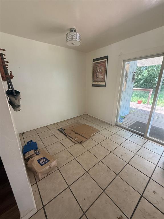 A tiled dining area features a modern light fixture and a sliding glass door to outside — 2188 NW 42ND AVENUE, GAINESVILLE, FL