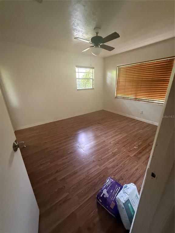 An empty bedroom features wood-look flooring, a ceiling fan, and a window with blinds — 2188 NW 42ND AVENUE, GAINESVILLE, FL