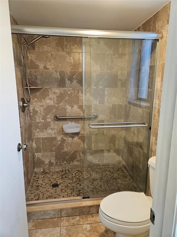 A bathroom features a walk-in shower with tiled walls, a glass door, and a toilet — 5583 Courtyard Drive # 5583, Margate FL 33063, MARGATE, FL