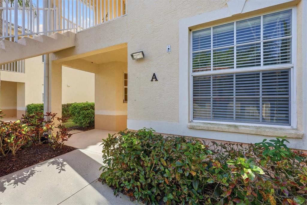The exterior of a stucco apartment building features a ground-level entrance labeled with an A — 4266 VICENZA DRIVE UNIT A39, VENICE, FL