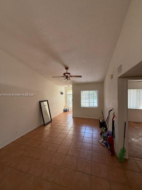 An empty room features tan tile flooring, a ceiling fan, and a large leaning mirror — 3171 Holiday Springs Blvd # 5, Margate FL 33063, MARGATE, FL
