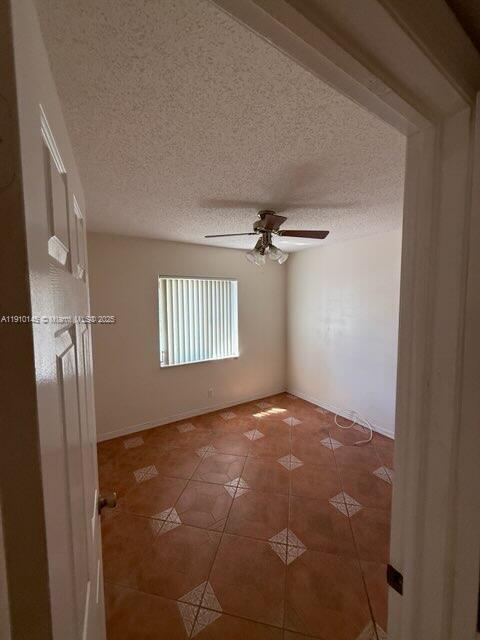 An empty bedroom with tan tile flooring, a ceiling fan, and a window with blinds — 3171 Holiday Springs Blvd # 5, Margate FL 33063, MARGATE, FL