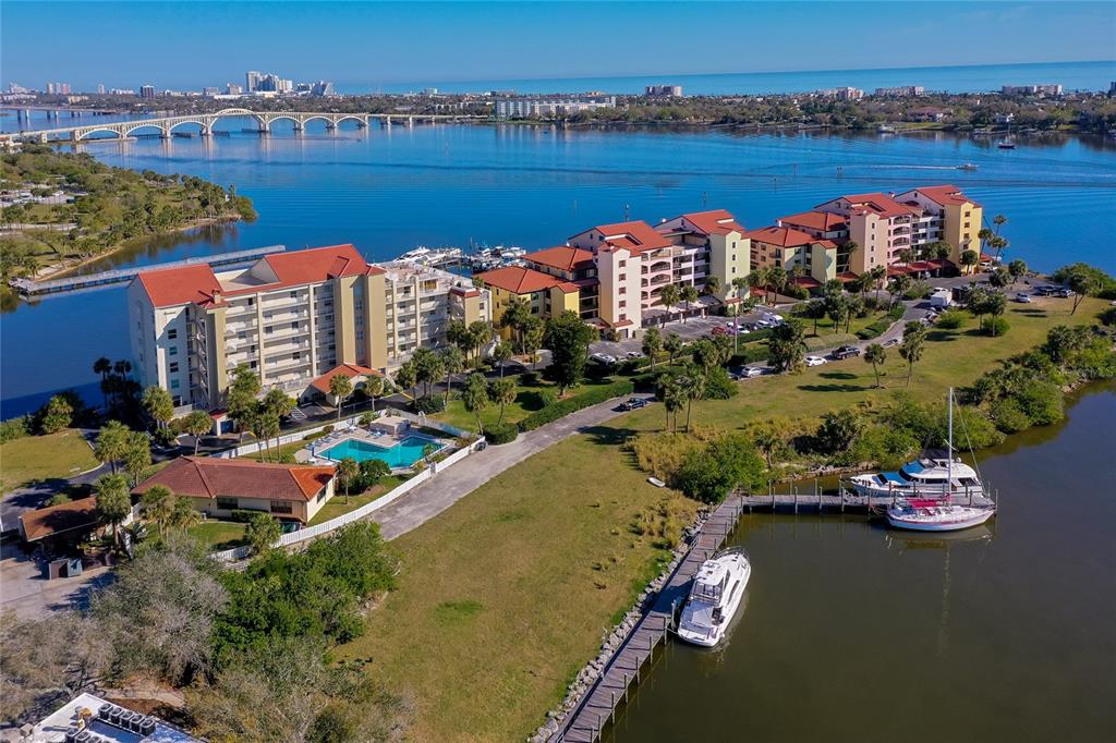 An aerial view shows a waterfront condominium complex with a pool and boat docks — 732 MARINA POINT DRIVE UNIT 7320, DAYTONA BEACH, FL