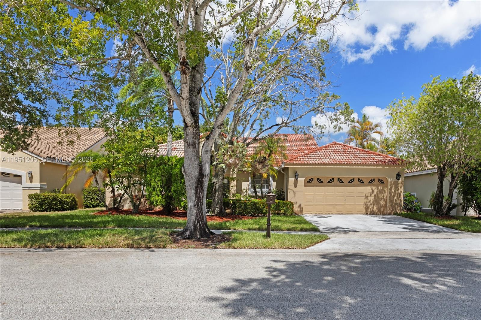 A single-story house with a tan stucco exterior, a tiled roof, and a two-car garage — 798 Verona Lake Dr, Weston FL 33326, WESTON, FL