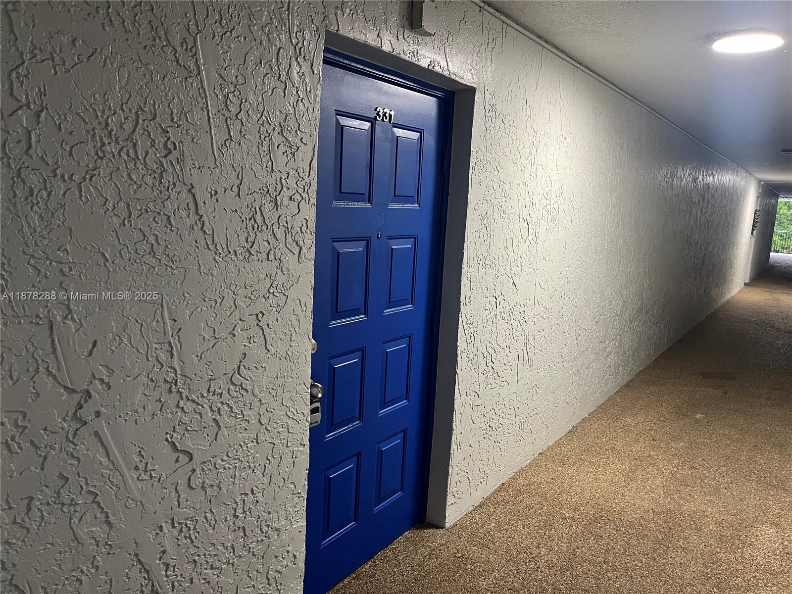 A blue door marked 331 is set into a textured white wall in a hallway — 3720 N Pine Island Rd # 331, Sunrise FL 33351, SUNRISE, FL