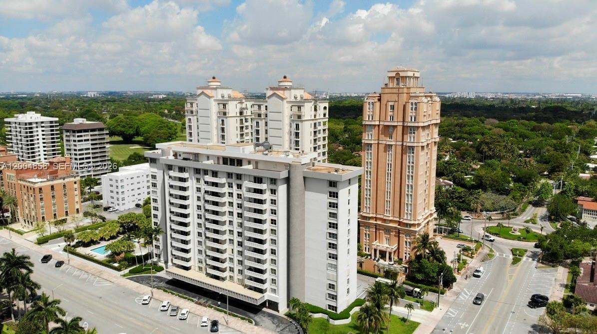 An aerial view shows several high-rise apartment buildings surrounded by lush green trees and roads — 625 Biltmore Way # 103, Coral Gables FL 33134, CORAL GABLES, FL