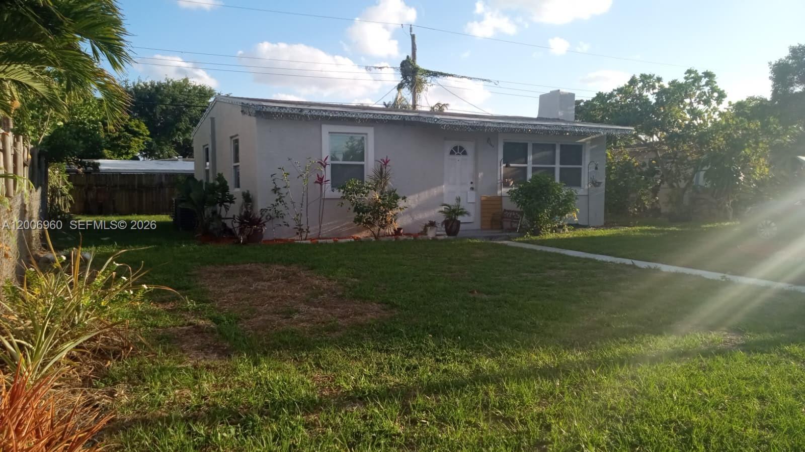 A single-story house with a light-colored exterior, a front yard, and a paved walkway — 508 Beech Rd, West Palm Beach FL 33409, WEST PALM BEACH, FL