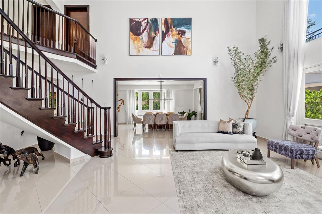 A bright living room features a staircase, a white sofa, and a dining area beyond — 446 DORADO BEACH EAST, DORADO, PR