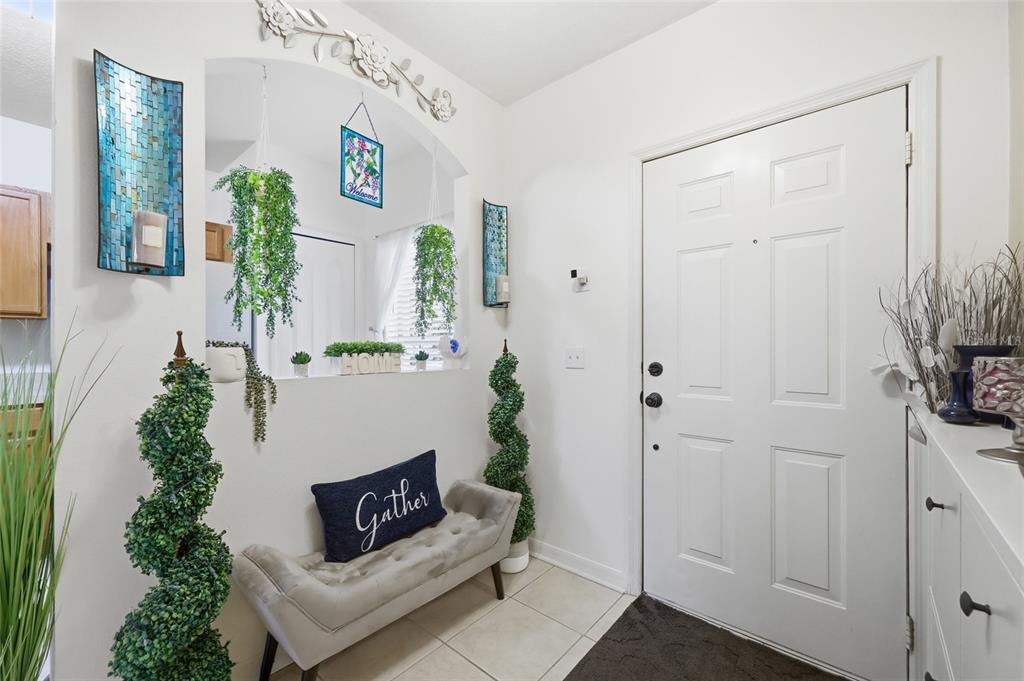 An entryway features a white door, a tufted bench, and a decorative arched wall cutout — 417 WILTON CIRCLE, SANFORD, FL