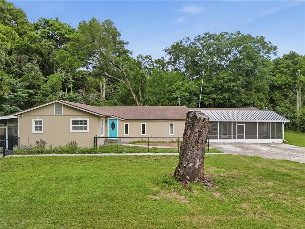 An above-ground swimming pool with a wooden deck sits in the backyard of a house — 8095 ROSE AVENUE, ORLANDO, FL